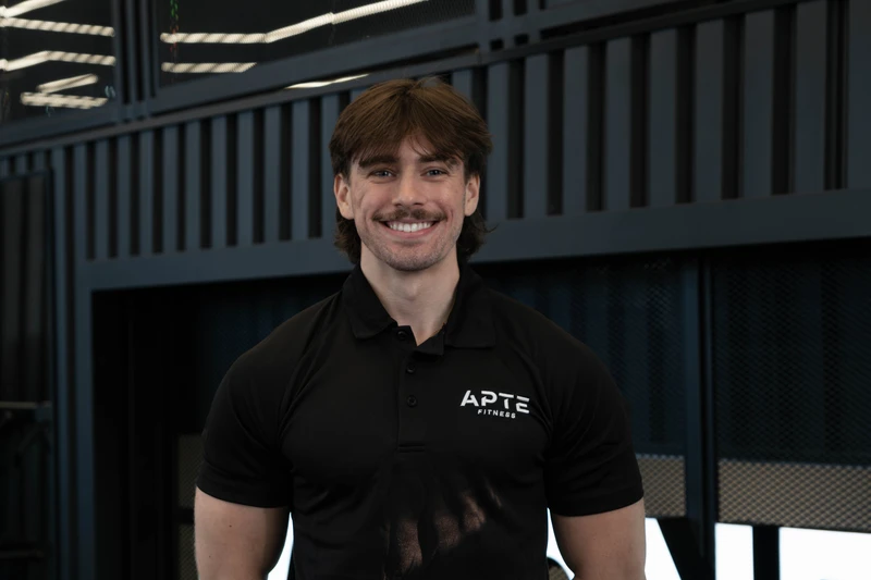 Entraîneur Alex debout, les bras croisées avec un sourire