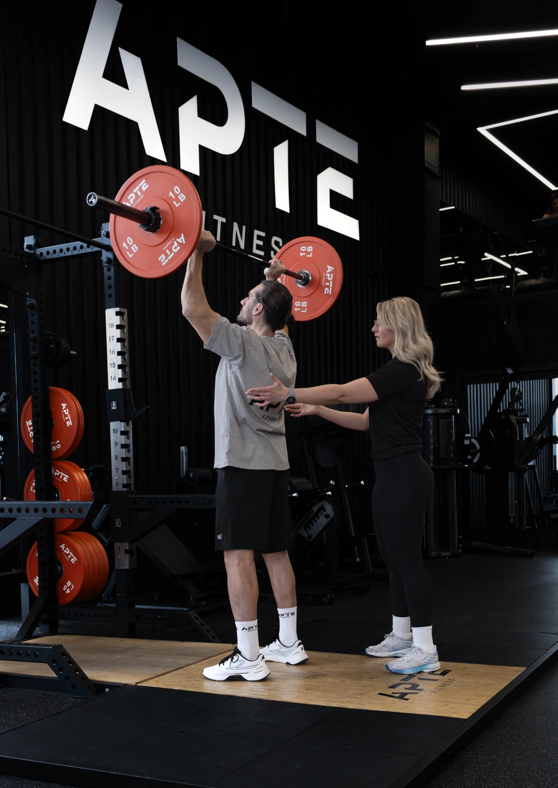 Entraîneur privé avec un membre dans le gym exclusif Apte Fitness